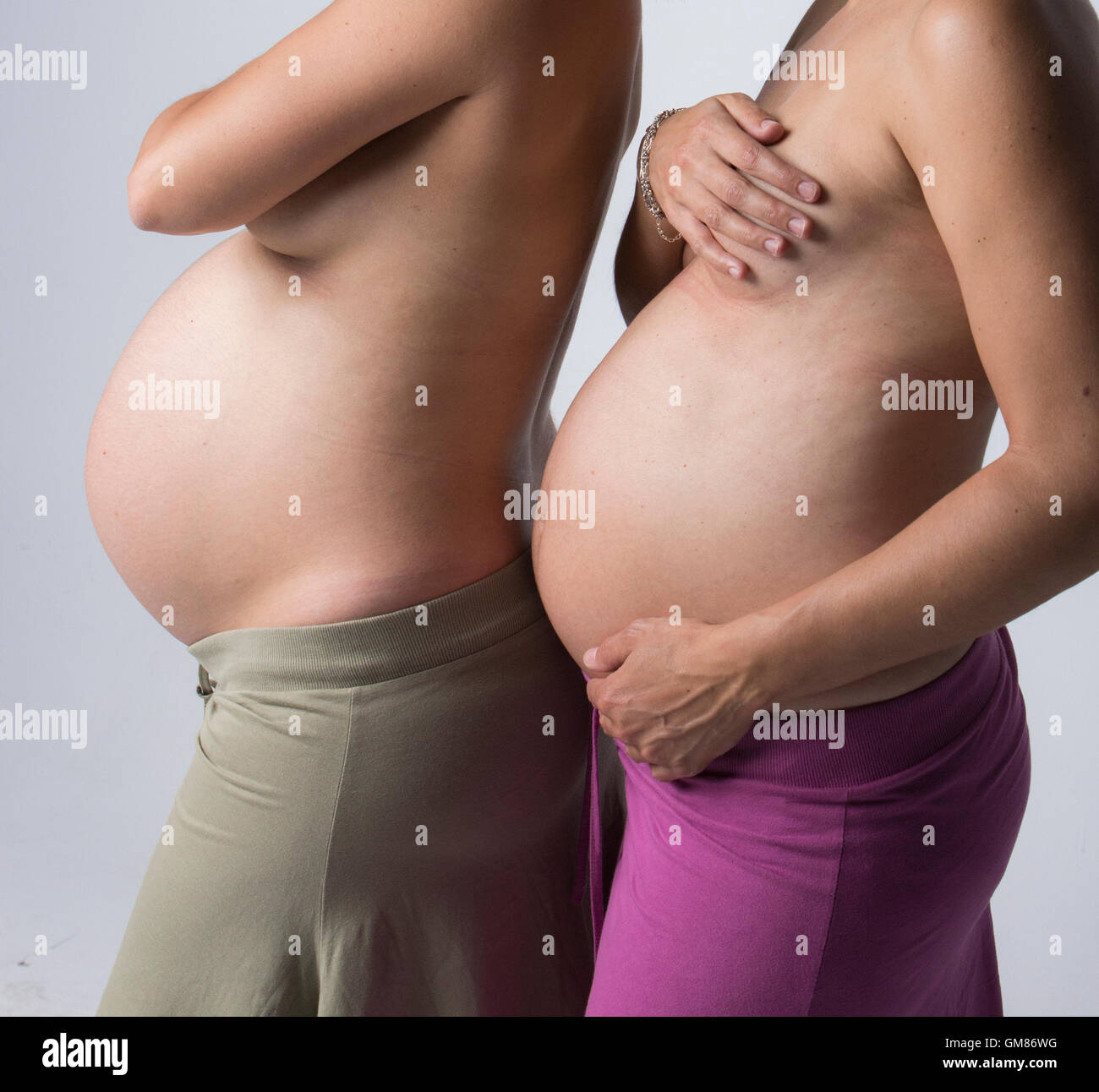 Schwangere Frauen halten ihre Hände auf schönen Bauch Stockfoto