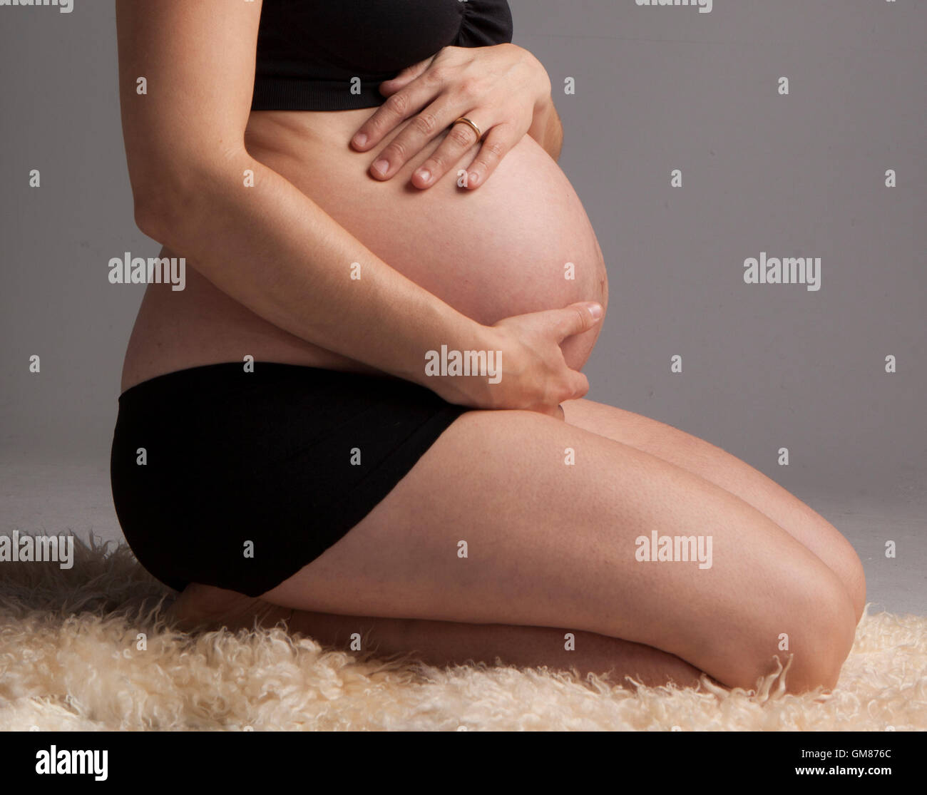 Schwangere Frau hielt ihre Hände auf schönen Bauch Stockfoto