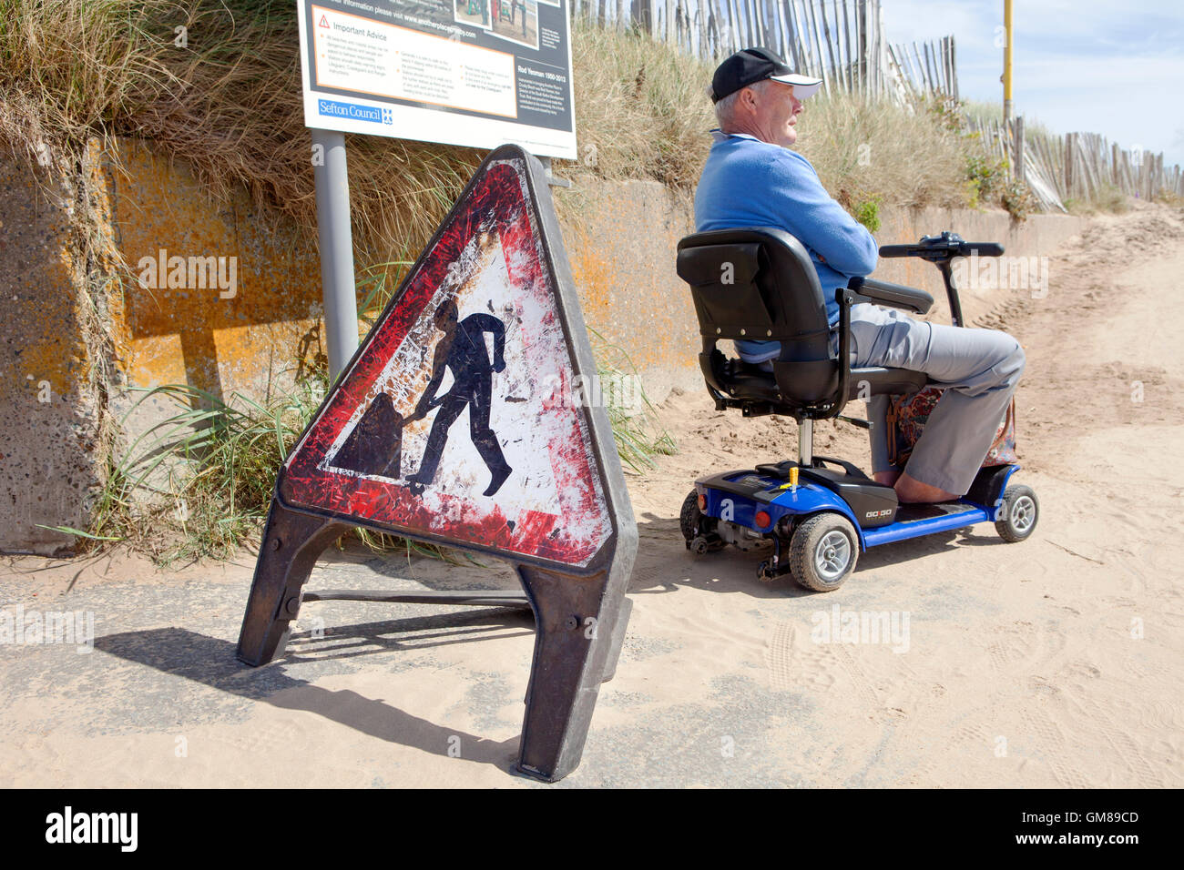 Behinderte Mensch auf Mobilität Motorroller, Mariners Weg, Crosby, Liverpool, Merseyside, Großbritannien Stockfoto