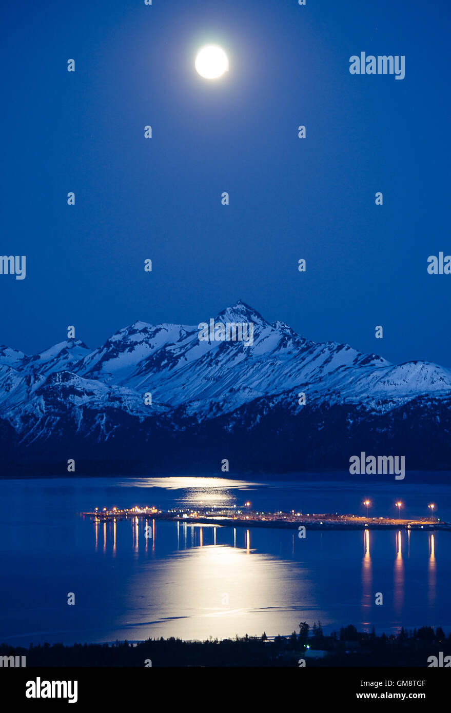 Der Mond wirft ein langes Lichtband über Kachemak Bay und Homer Spit. Stockfoto