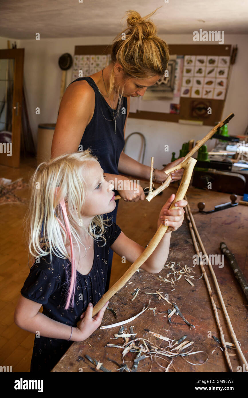 Mutter und Tochter in der Werkstatt arbeiten auf Steinzeit Speer-Werfer Stockfoto