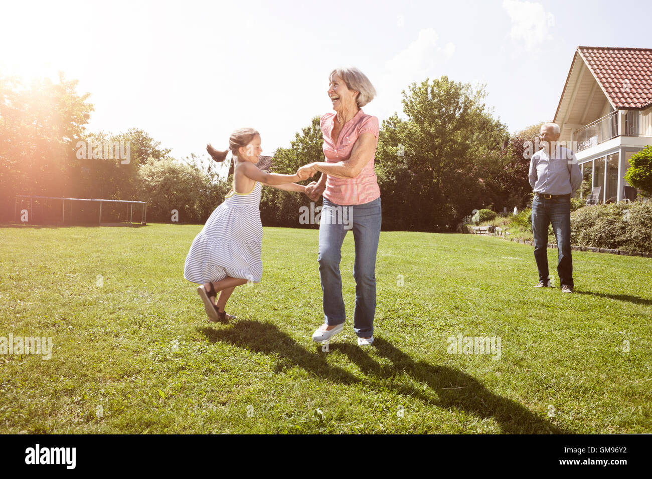 Verspielte Oma mit Enkelin im Garten Stockfoto