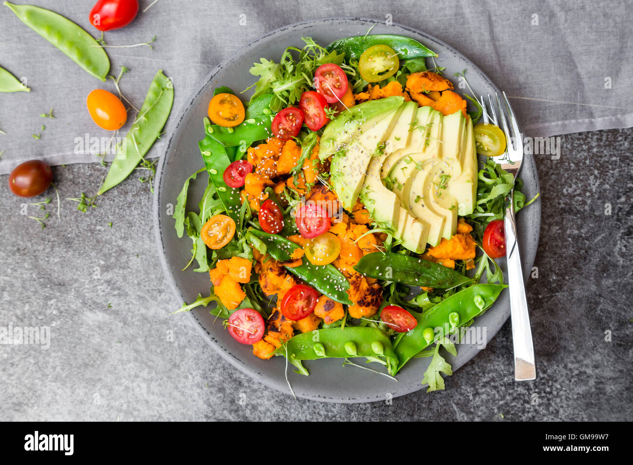 Frischer Salat mit Rucola, Süßkartoffel, Avocado, Tomate, Chiasamen, Snow pea Stockfoto