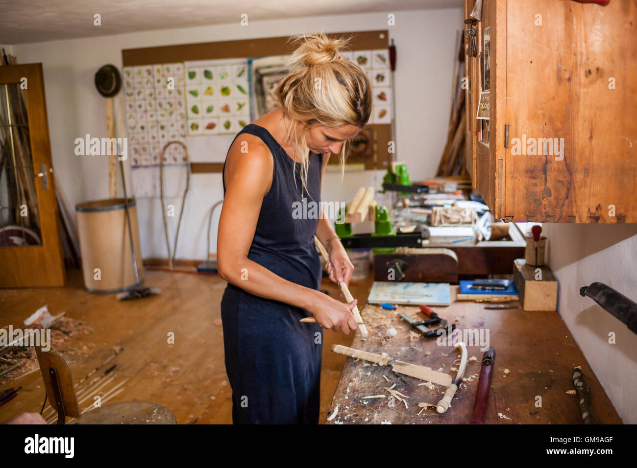 Frau in der Werkstatt arbeiten auf Steinzeit Speer-Werfer Stockfoto