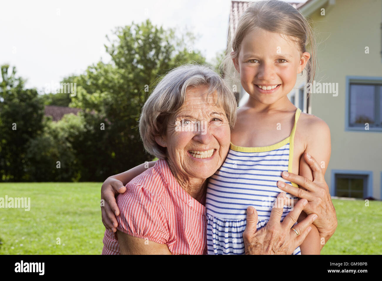 Porträt der glückliche Großmutter und Enkelin im Garten Stockfoto
