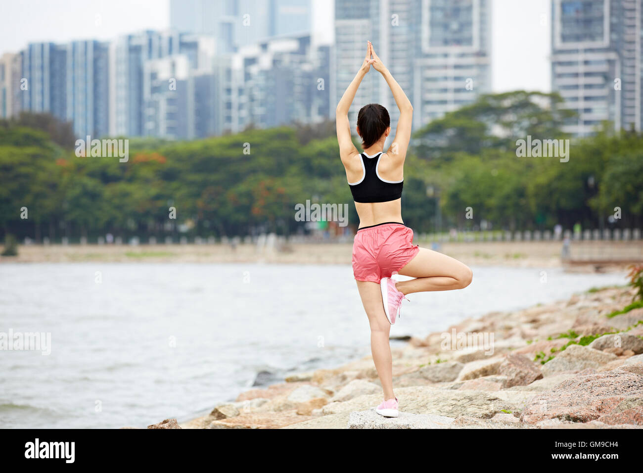 junge asiatische Frau, Yoga zu praktizieren oder Abwägung See im Stadtpark zu tun. Stockfoto