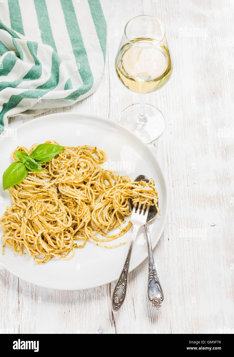 Pasta Spaghetti mit Pesto-Sauce, Basilikum, Glas Weißwein Stockfoto