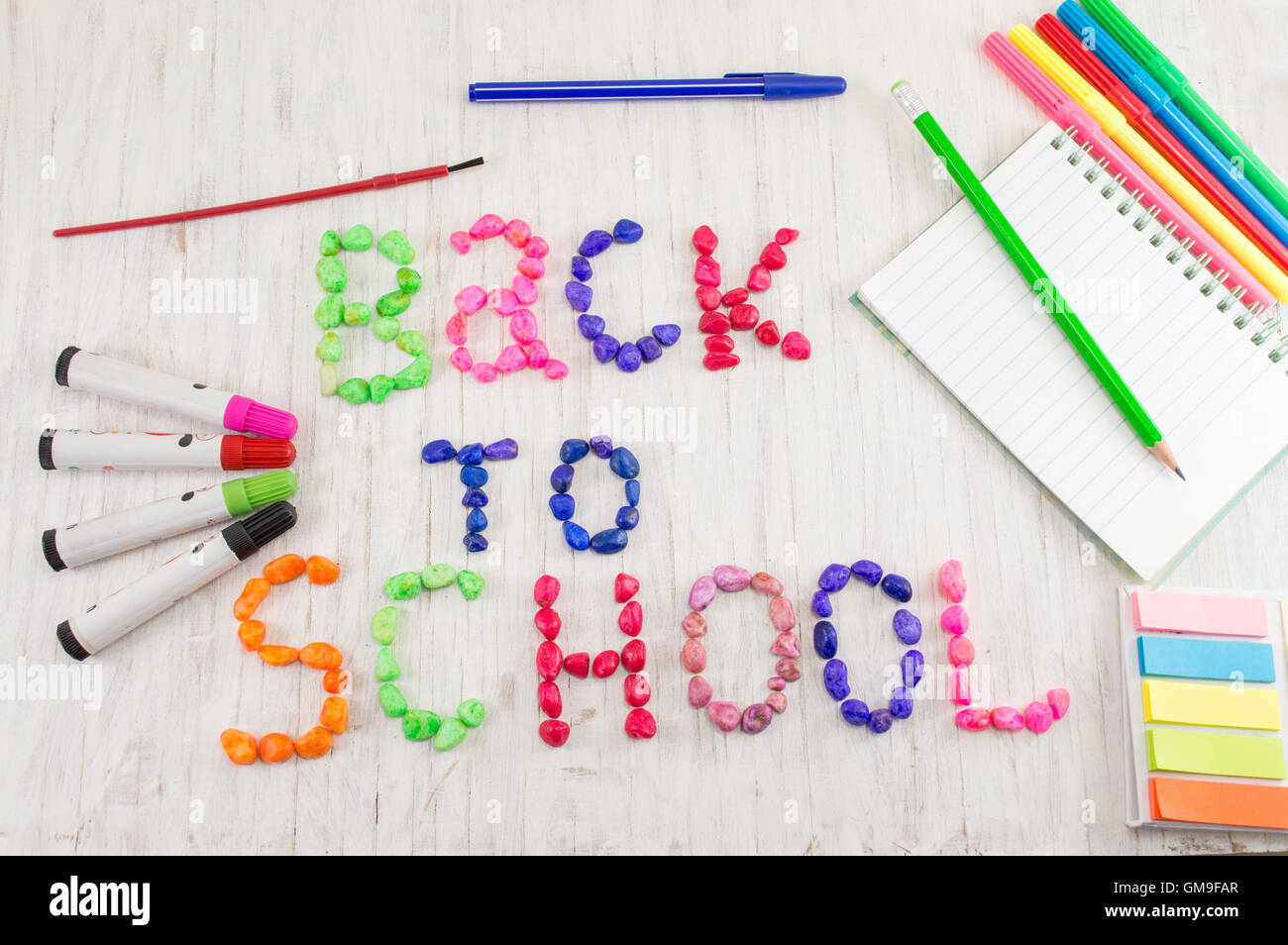 Zurück zur Schule geschrieben, mit bunten Steinen und Lerntools Stockfoto