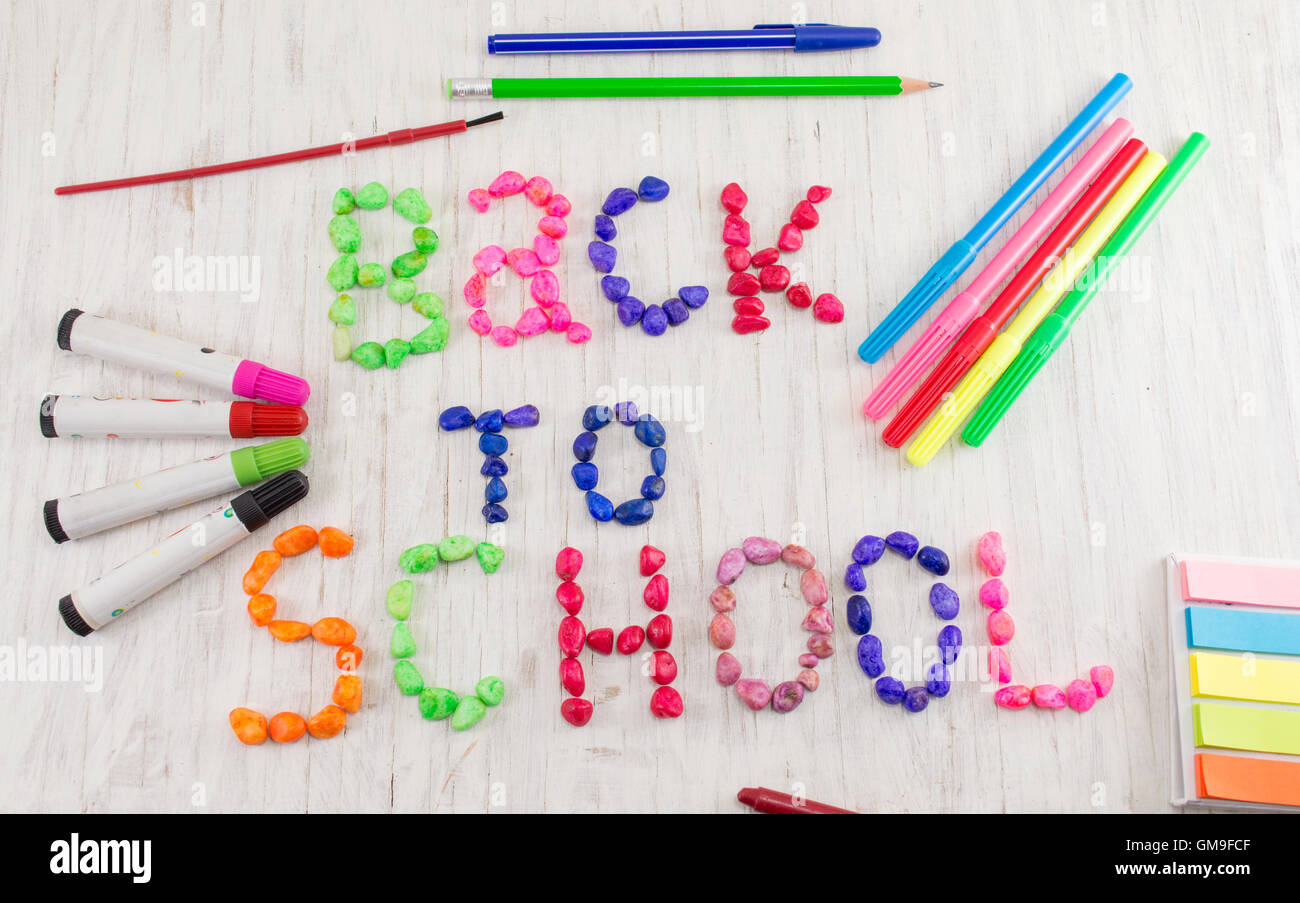 Zurück zur Schule geschrieben, mit bunten Steinen und Lerntools Stockfoto