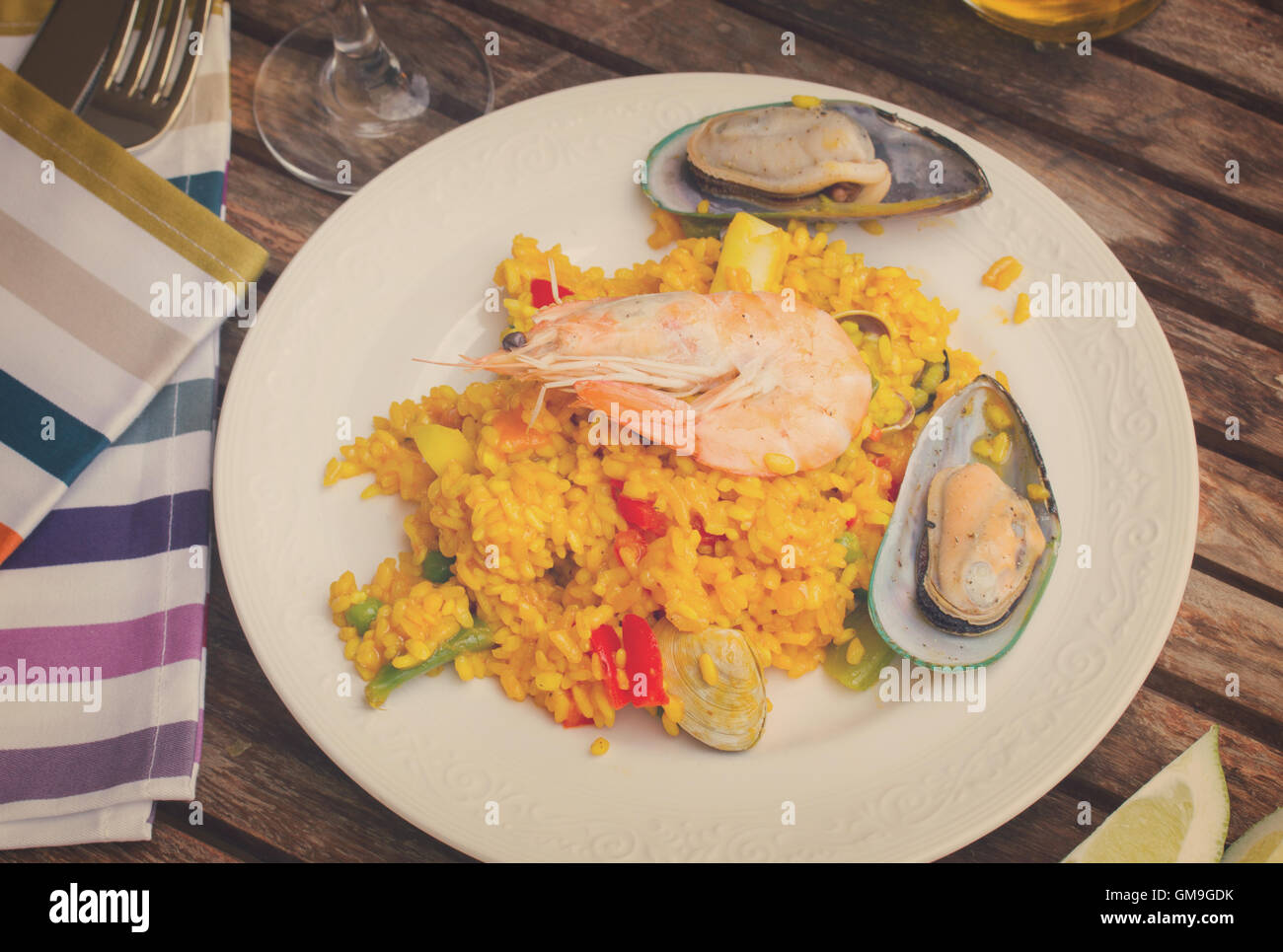 Paella serviert in Platte auf Holztisch Stockfoto