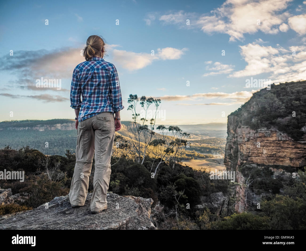 Australien, New South Wales, Blue Mountains, Blackheath, Megalong Valley, Reife Frau stehen auf Felsen und mit Blick auf Tal Stockfoto