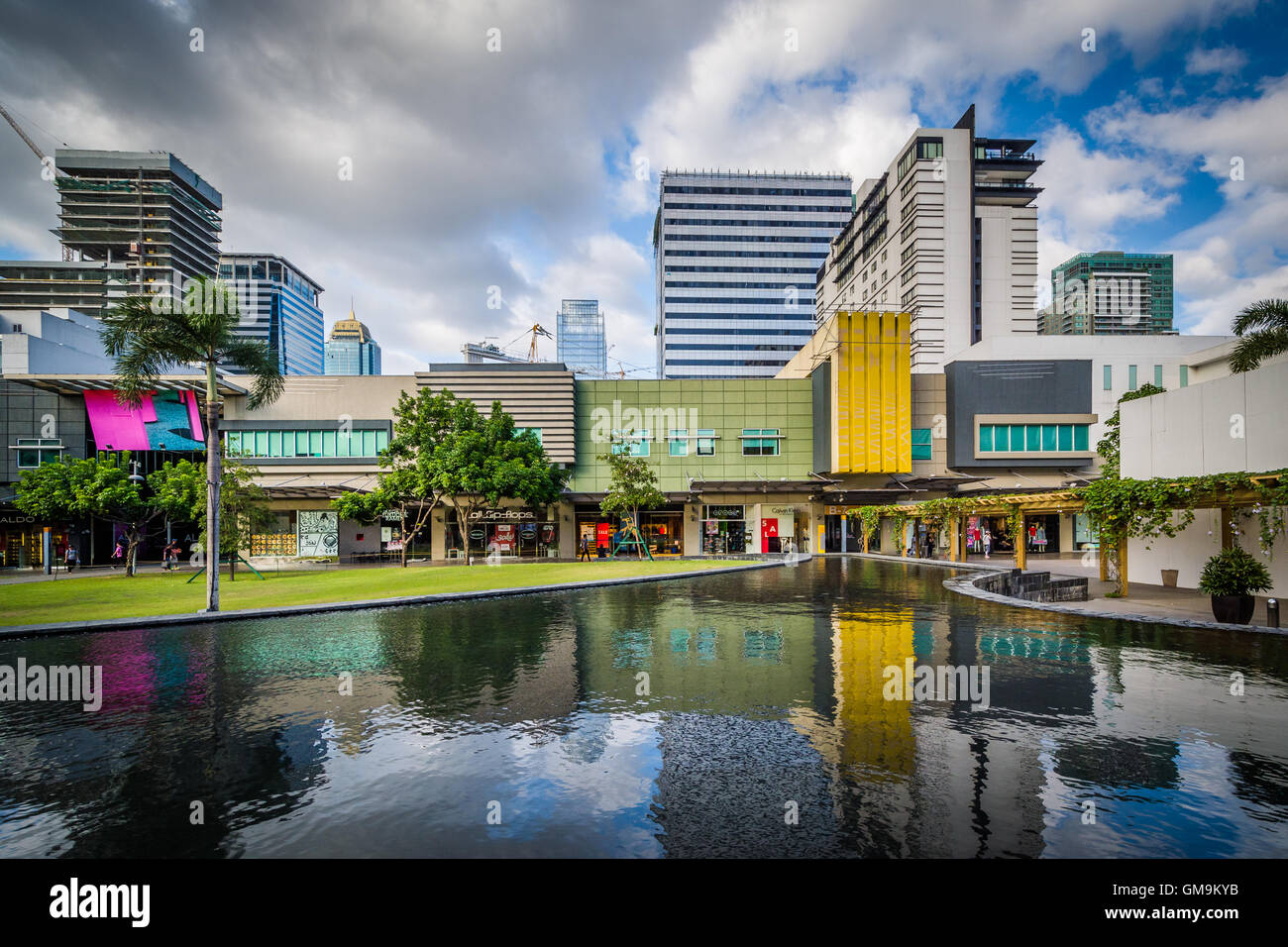 Palmen Sie und modernen Gebäuden reflektiert in einem Pool am Bonifacio Global City in Taguig, Metro Manila, Philippinen. Stockfoto