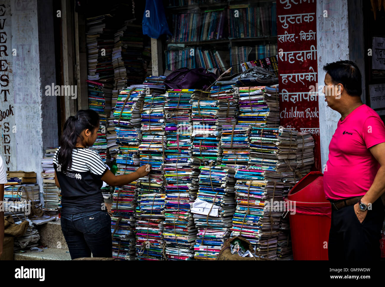 ein Mädchen in einer Prozession zur Auswahl eines Buches in einer Buchhandlung in Kathmandu Stockfoto