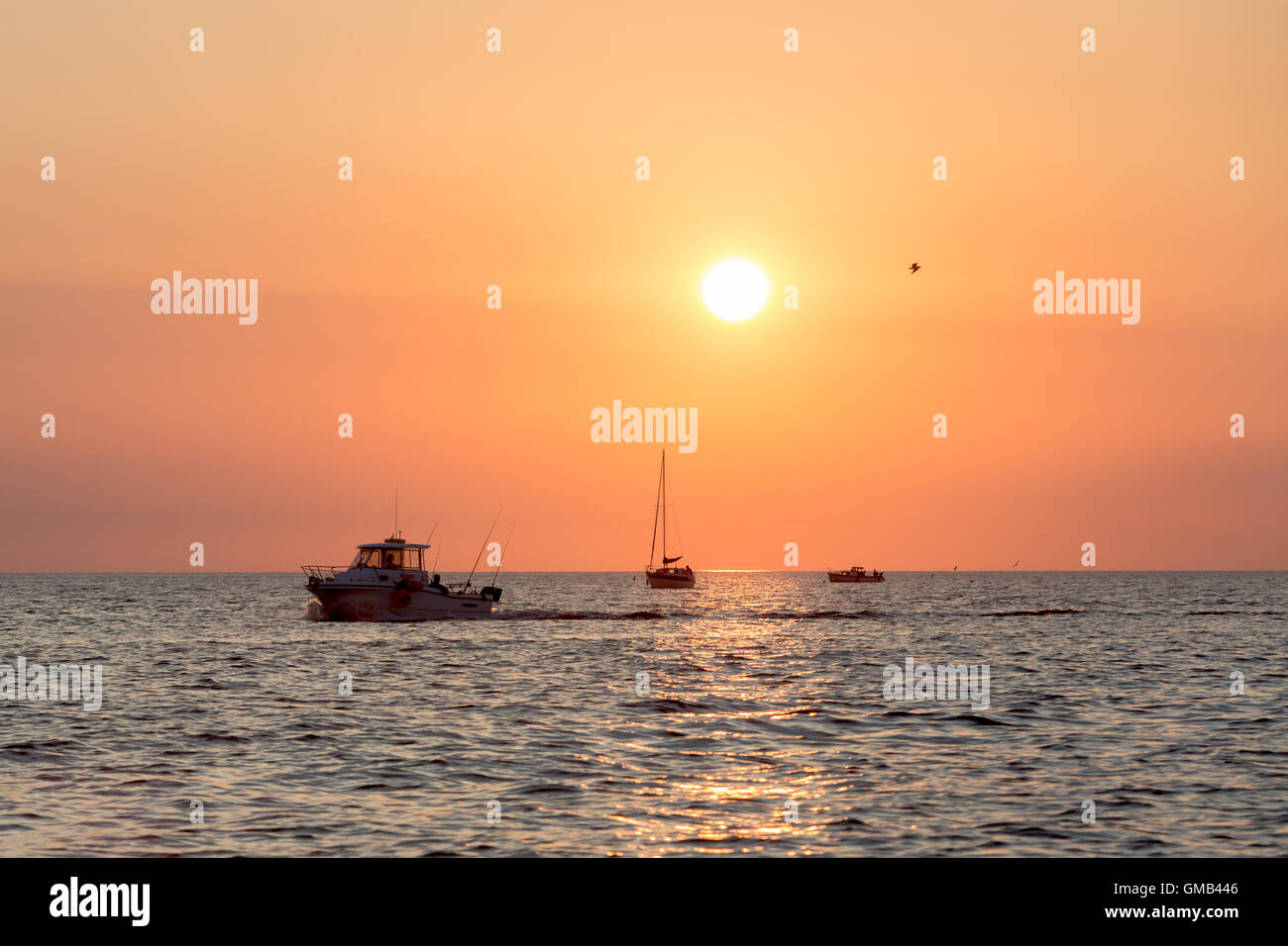 3 kleine Boote auf der Westküste zurück ins Land bei Sonnenuntergang Stockfoto