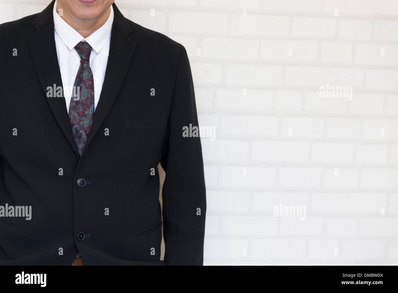 Geschäftsmann hand in der Tasche stehen neben weißen Wand Stockfoto