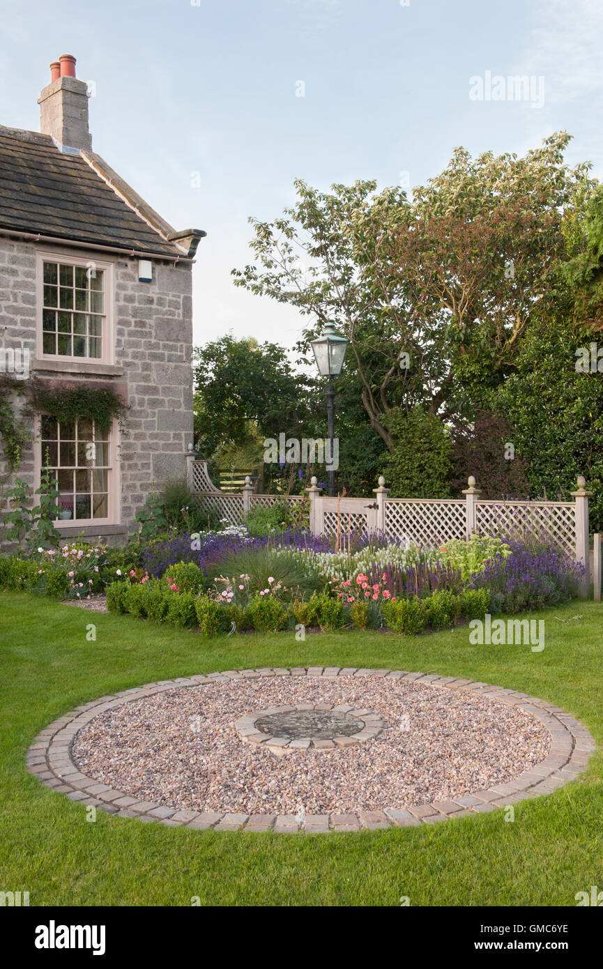 Asphaltierte Kreisfläche und Blumen in einem traditionellen, gestaltete, gepflegte, Bauerngarten - North Yorkshire, England. Stockfoto