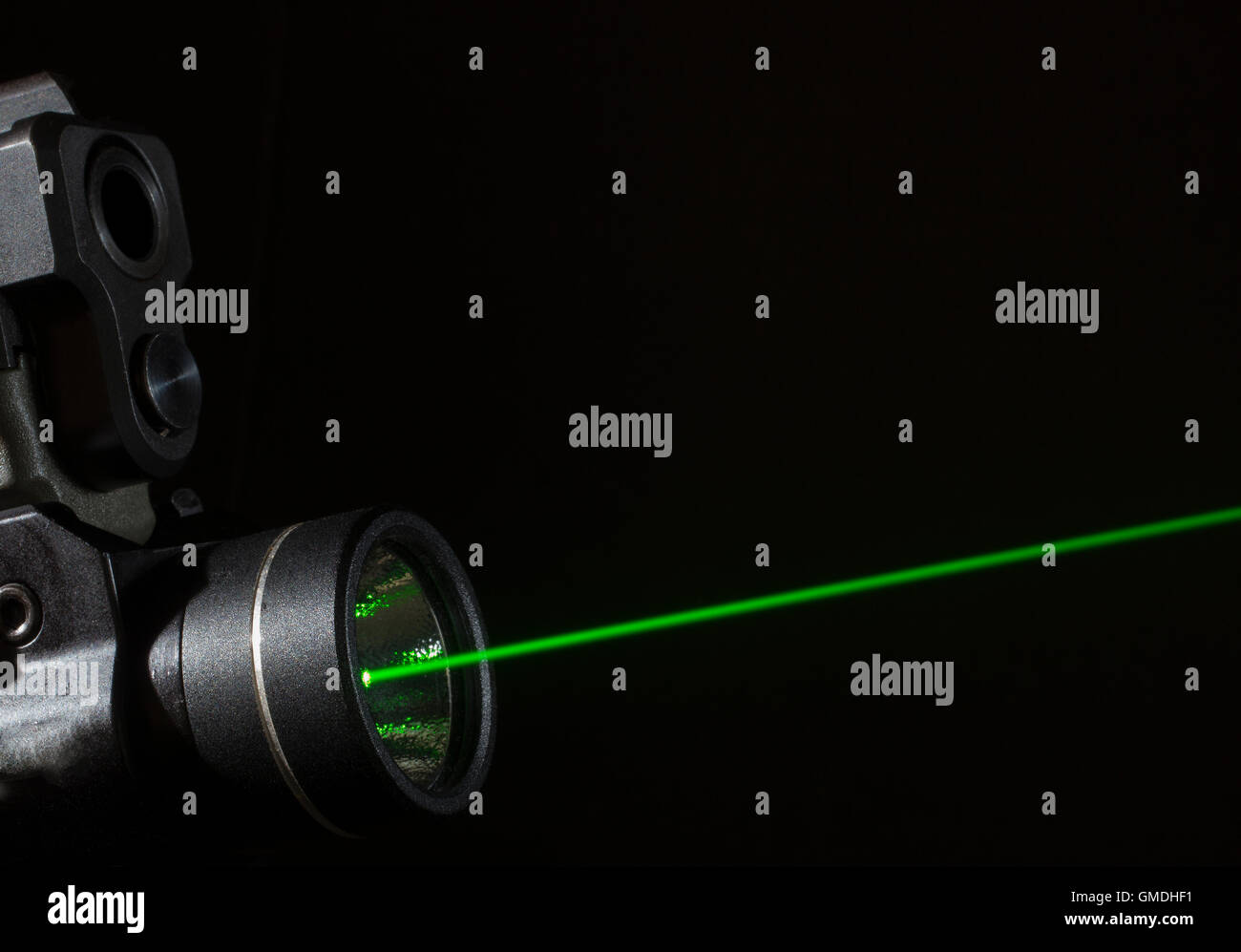 Grüner Laser, der auf dem Boden einer Handfeuerwaffe montiert ist Stockfoto