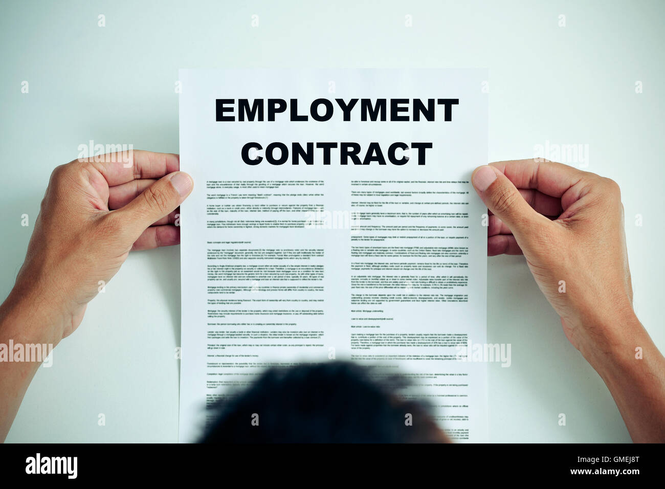 Closeup von einem kaukasischen Jüngling lesen die Bedingungen des Arbeitsvertrags Stockfoto