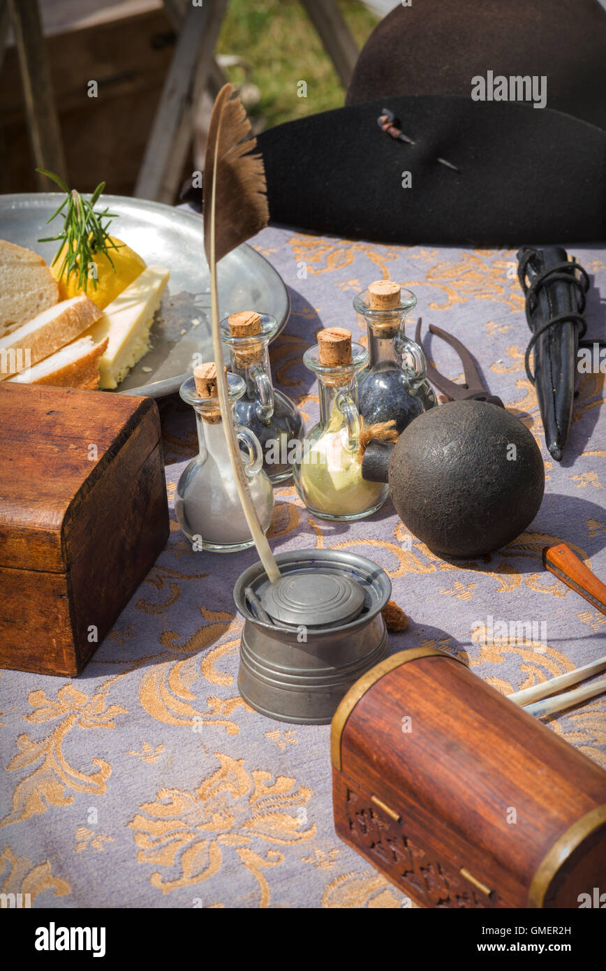 Englischer Bürgerkrieg Royalist Tisch mit einer Kanonenkugel, Schießpulver, Feder und andere Gegenstände auf einem Reenactment, Spetchley Park, England Stockfoto