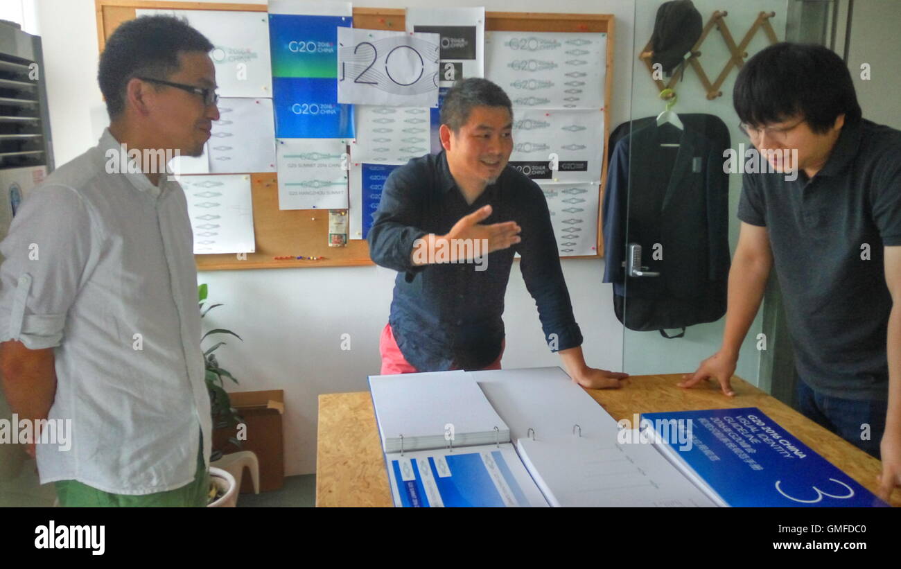 (160827)--HANGZHOU, 27. August 2016 (Xinhua)--Designer Yuan Youmin (C), Fang Hongzhang (L) und Sui Huanchen diskutieren einen Plan entwerfen in ihrem Studio in Hangzhou, Hauptstadt der ostchinesischen Provinz Zhejiang, 12. August 2016. Mit dem Bild einer Brücke, ergänzt mit dem Aufdruck einer traditionellen chinesischen Dichtung, entwarf das Logo des bevorstehenden G20-Gipfels Yuan Youmin von der China Academy of Art in Hangzhou und seine Partner Fang Hongzhang und Sui Huanchen. Die Brücke besteht aus 20 Zeilen, und der Bogen der Brücke bildet einen Kreis mit seinen Überlegungen. Die 20 Linien repräsentiert Stockfoto