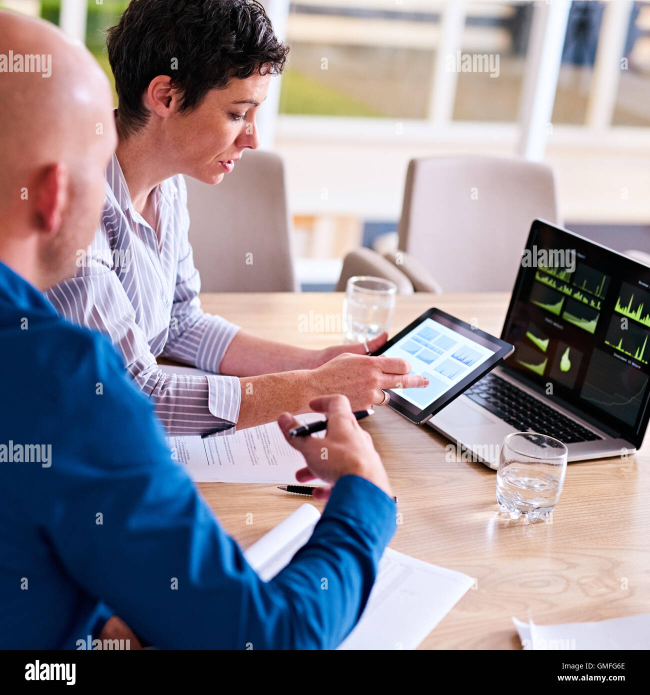Reife Geschäftsfrau beschäftigt mit ihrer Partneranalyse auf elektronische tablet Stockfoto