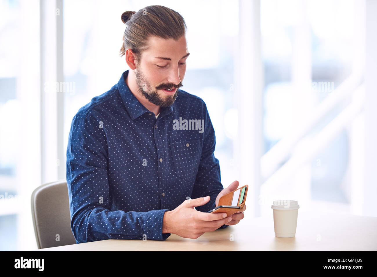 Hipster Mit Mann Brotchen Mit Seinem Handy Am Tisch Sitzen Stockfotografie Alamy