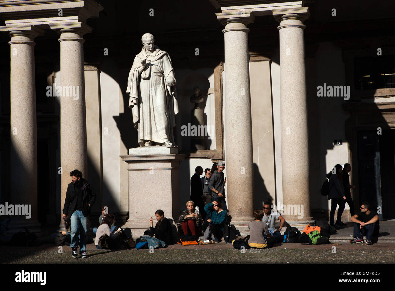 Studenten der Brera Akademie sitzen neben dem Denkmal an italienischen Mathematiker Bonaventura Cavalieri (1844) von dem italienischen Bildhauer Giovanni Antonio Labus im Innenhof des Palazzo di Brera in Mailand, Lombardei, Italien. Stockfoto