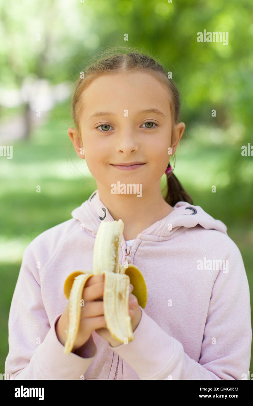 Mädchen hält Banane Stockfoto