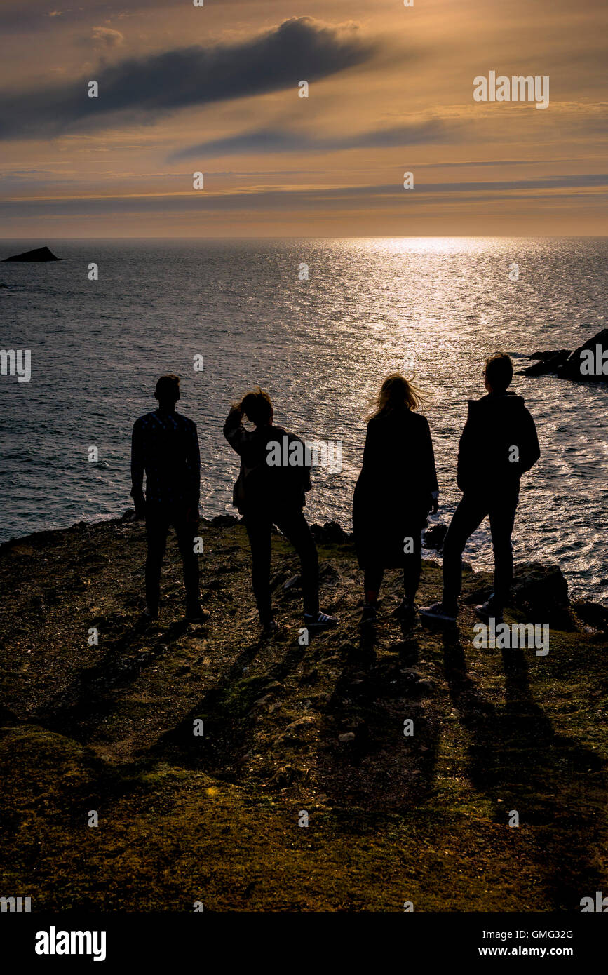 Vier Freunde genießen Sie einen herrlichen Sommerabend auf Osten Pentire Headland in Newquay, Cornwall. Stockfoto