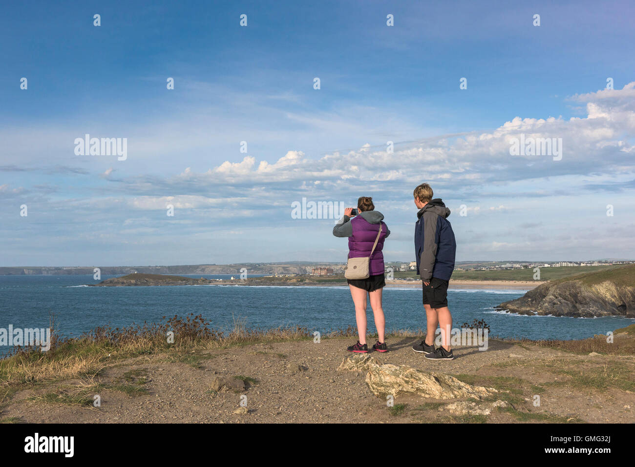 Urlauber stehen auf Osten Pentire Headland in Newquay, Cornwall. Stockfoto