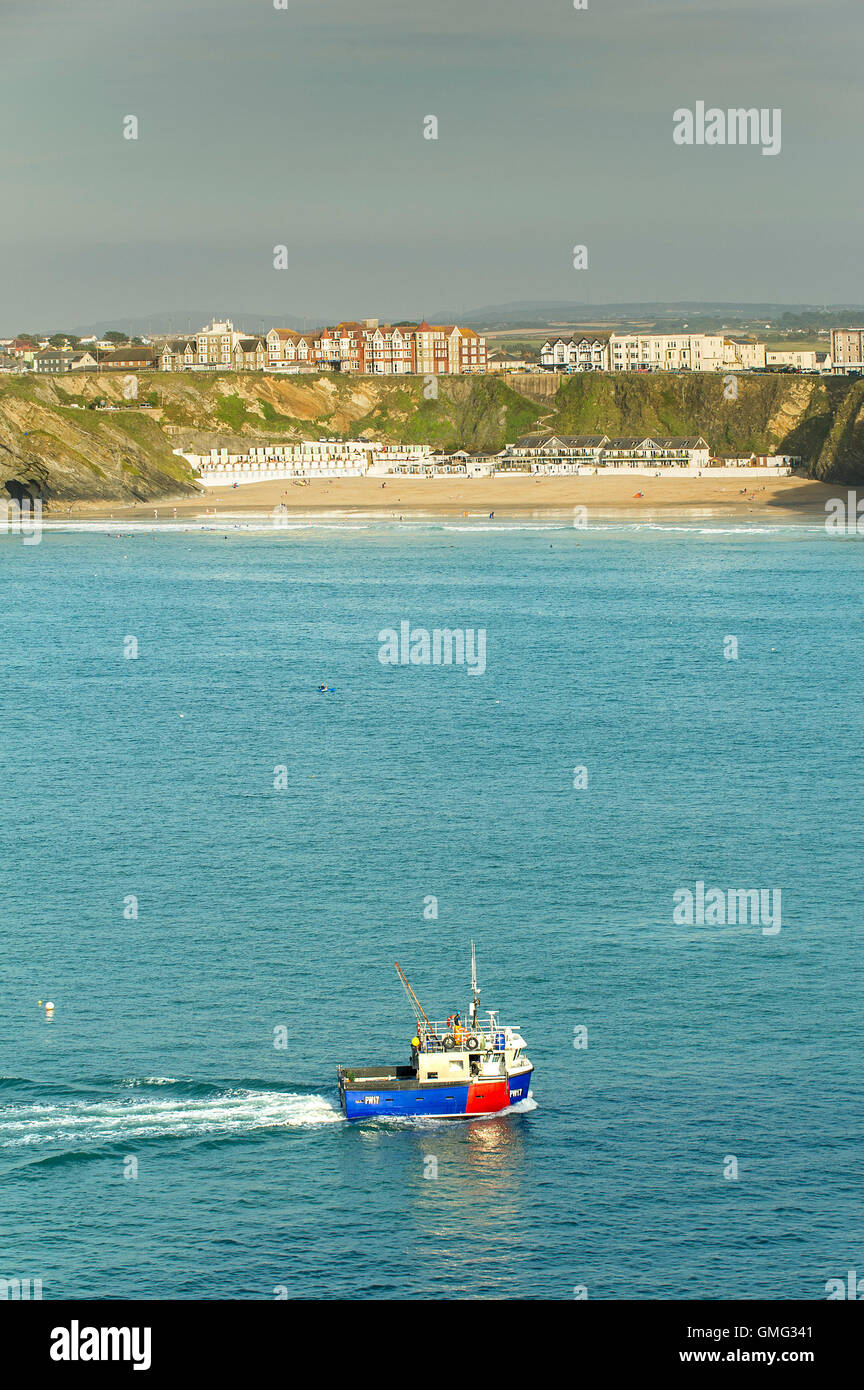 Ein Fischerboot dampft vorbei herzhaft Glasur Beach in Newquay, Cornwall. Stockfoto