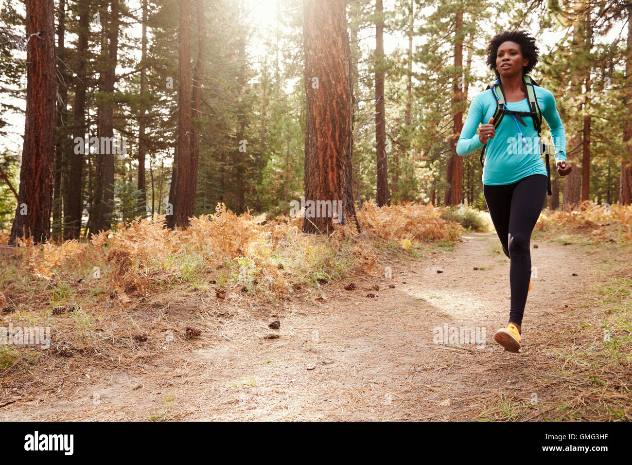 Afrikanische amerikanische Ethnizität Frau läuft in einem Wald Stockfoto