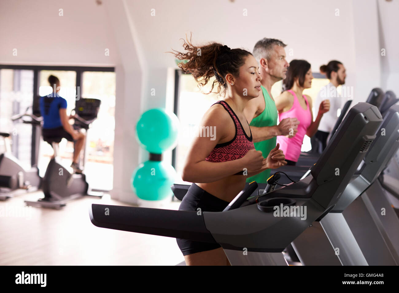 Personen mit Ausrüstung im anstrengenden Fitness-Studio Stockfoto