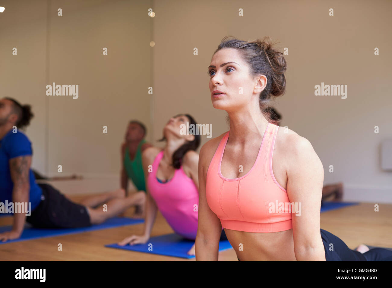 Ausbilder mit Yoga-Kurs im Fitness-Studio Stockfoto