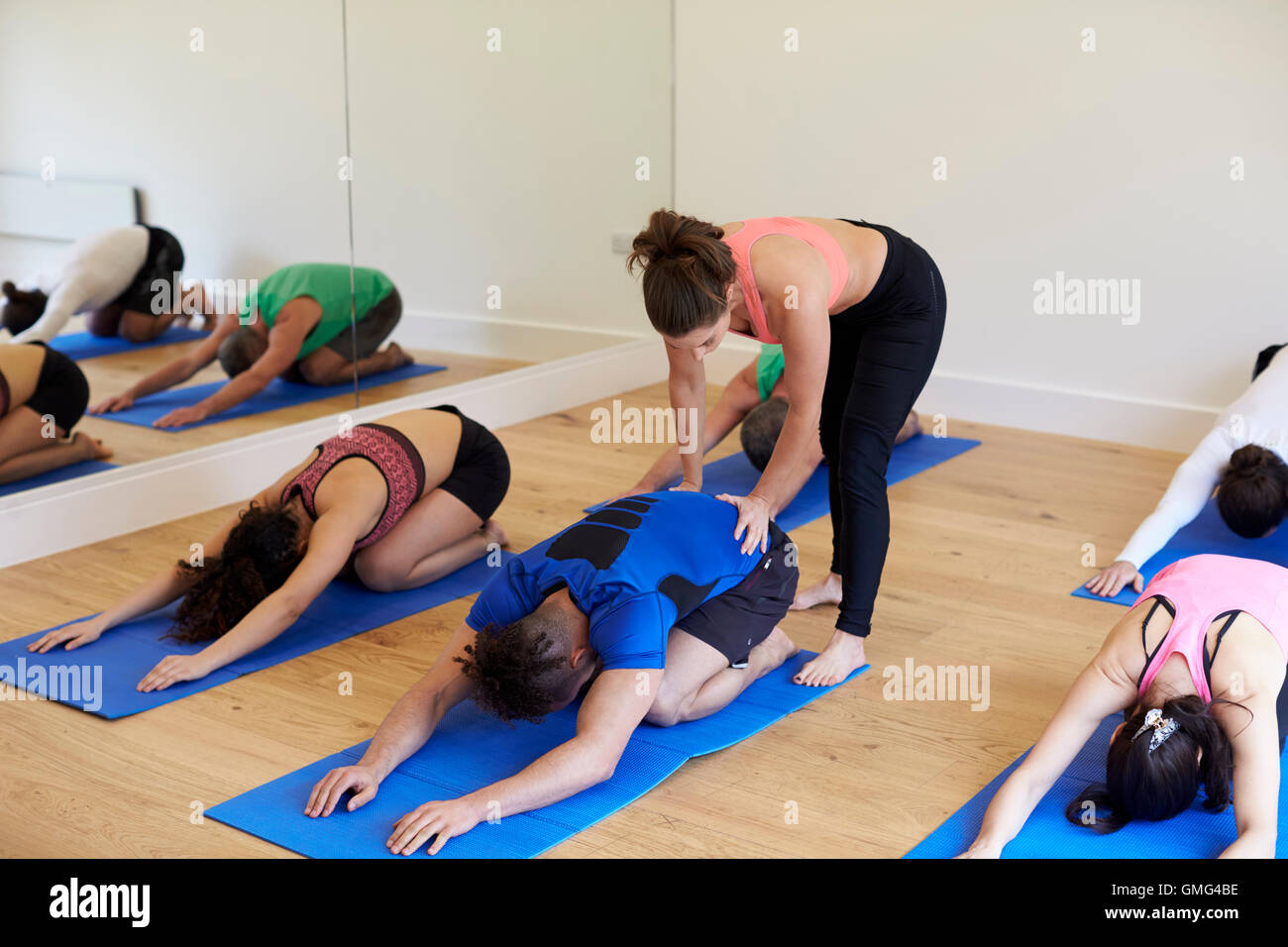Ausbilder mit Yoga-Kurs im Fitness-Studio Stockfoto