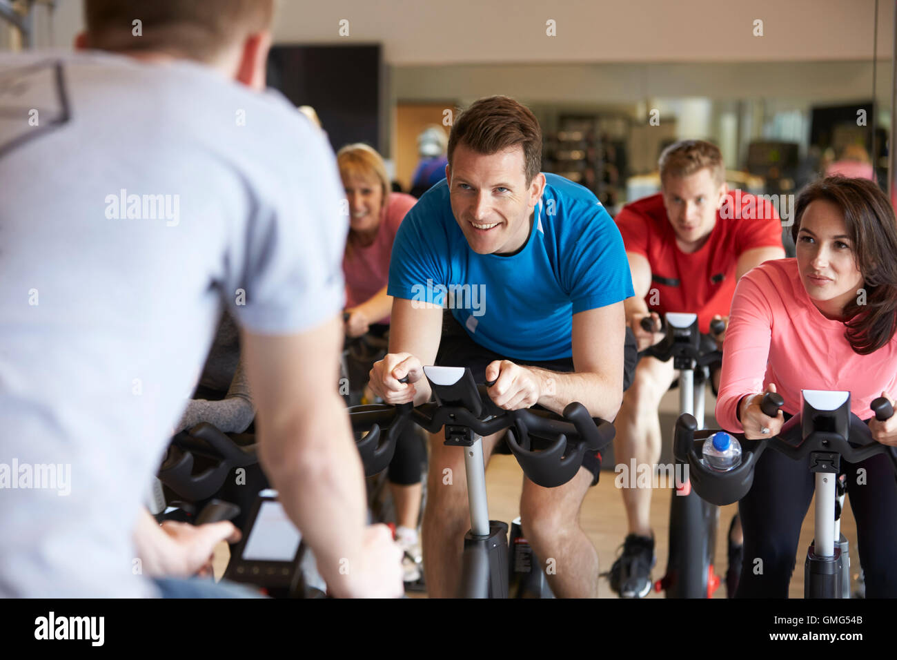 Ausbilder im Vordergrund mit spinning-Klasse in einem Fitnessstudio Stockfoto