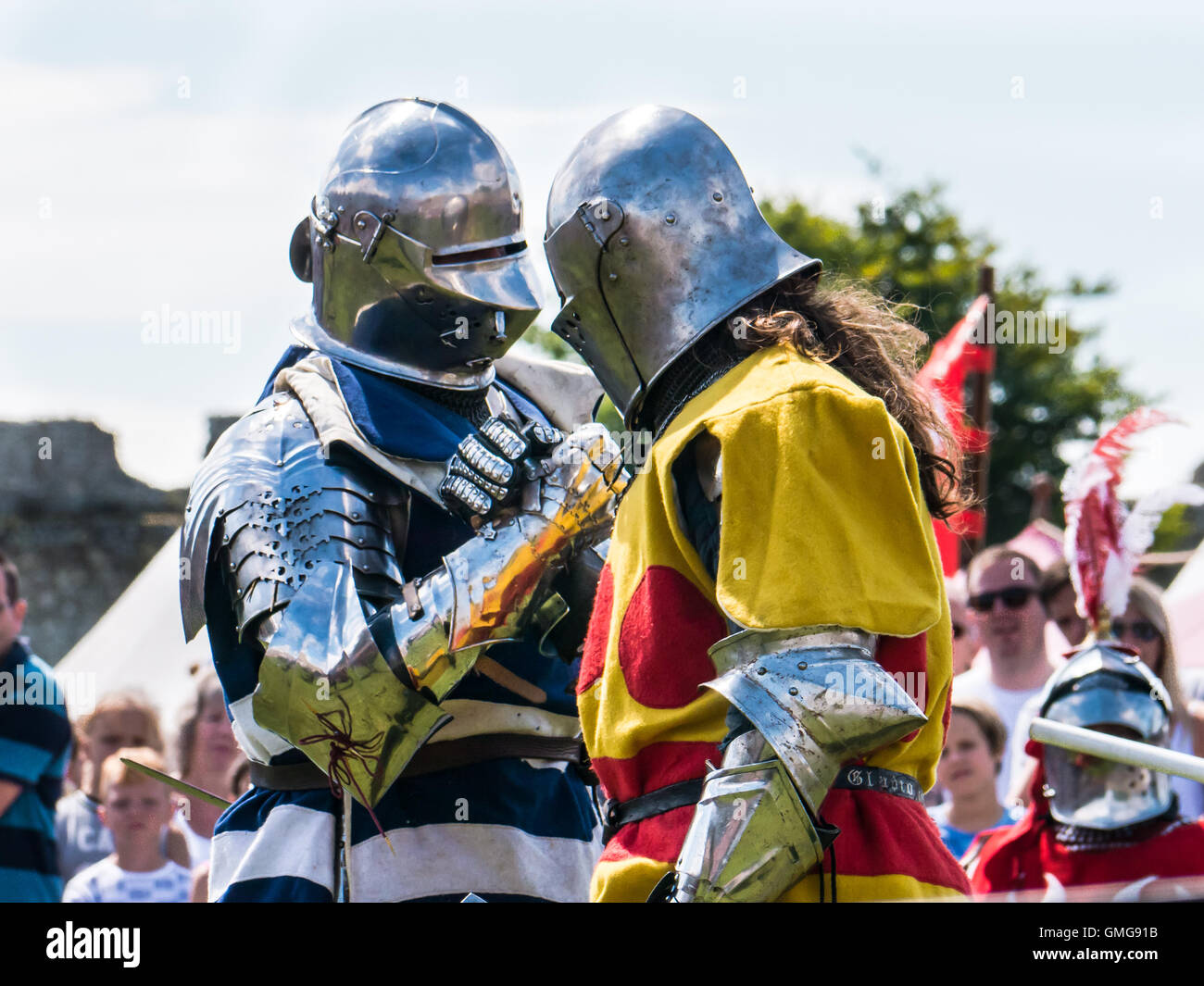 Zwei mittelalterliche Bekämpfung Reenactors in voller Rüstung schütteln sich die Hände vor der Bekämpfung Stockfoto