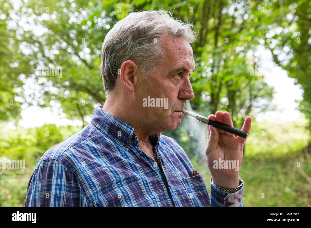 Mann-Dampfen mit der e-Zigarette außerhalb Irlands Stockfoto