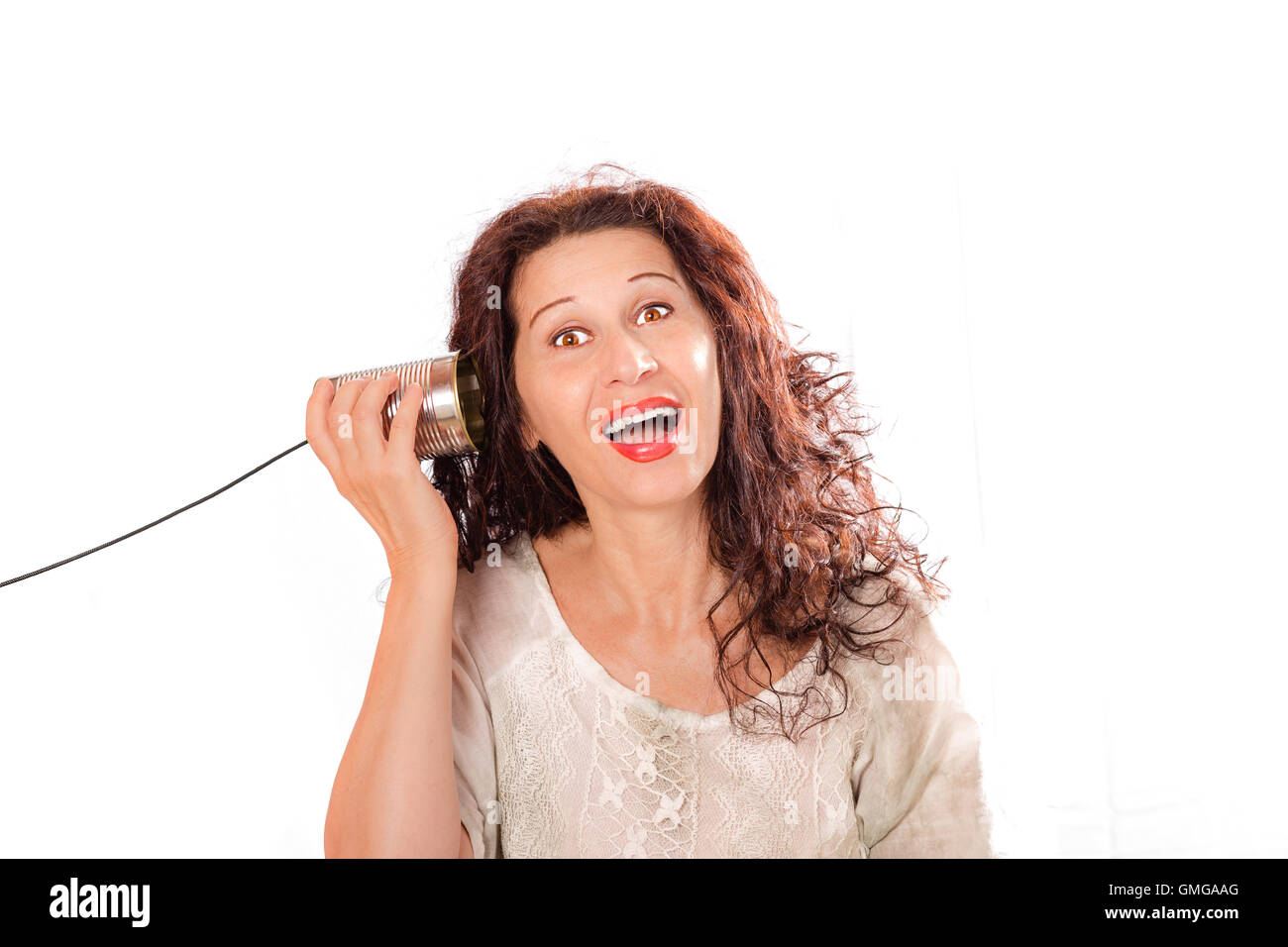 Porträt von einen netten mittlere gealterte Frau hören durch Blechdose Telefone über einen weißen Hintergrund isoliert Stockfoto