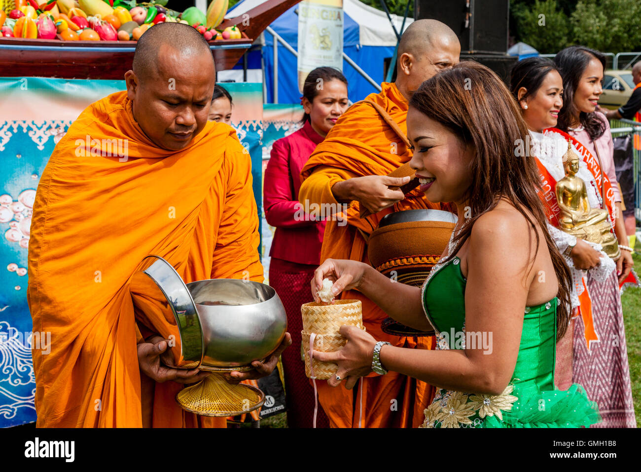 Thais anzubieten essen zwei Mönche an der Brighton Thai Festival, Preston Park, Brighton, Sussex, UK Stockfoto