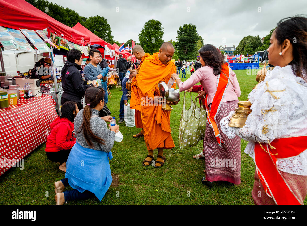 Thais anzubieten essen zwei Mönche an der Brighton Thai Festival, Preston Park, Brighton, Sussex, UK Stockfoto