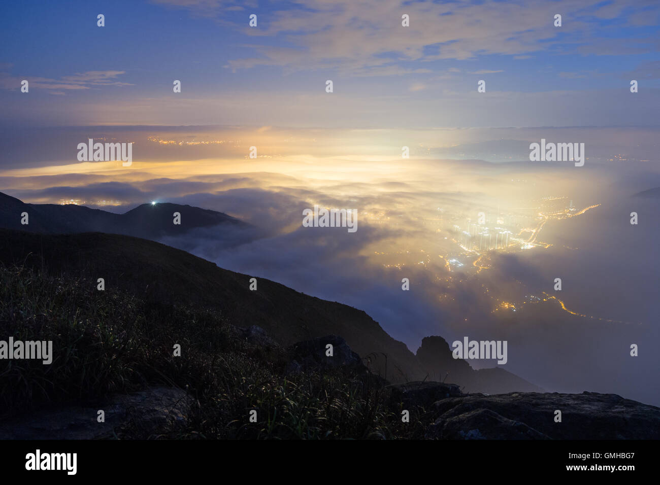 Lichter der Tung Chung Neustadt unter Wolken auf Lantau Island, gesehen vom Lantau Peak in Hong Kong, China. Stockfoto
