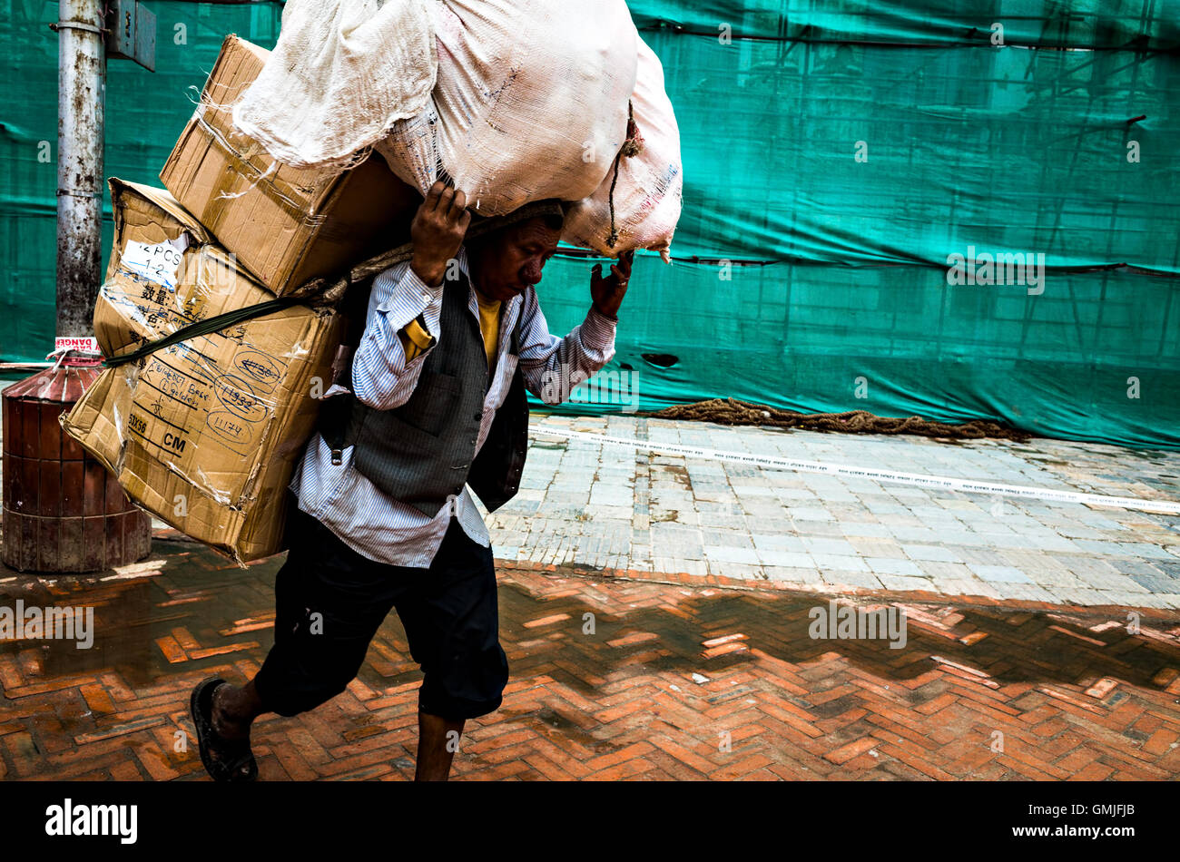 ein Portier hart bei der Arbeit mit vielen Karikaturen und Gepäck in Kathmandu Stockfoto