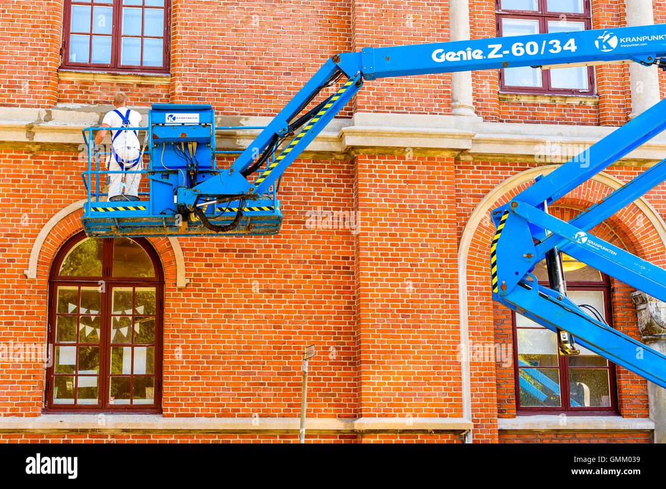 Lund, Schweden - 24. August 2016: Mason arbeitet mit Reparaturen an einem Gebäude stehen in einer Hubarbeitsbühne oder Aufzug. Stockfoto