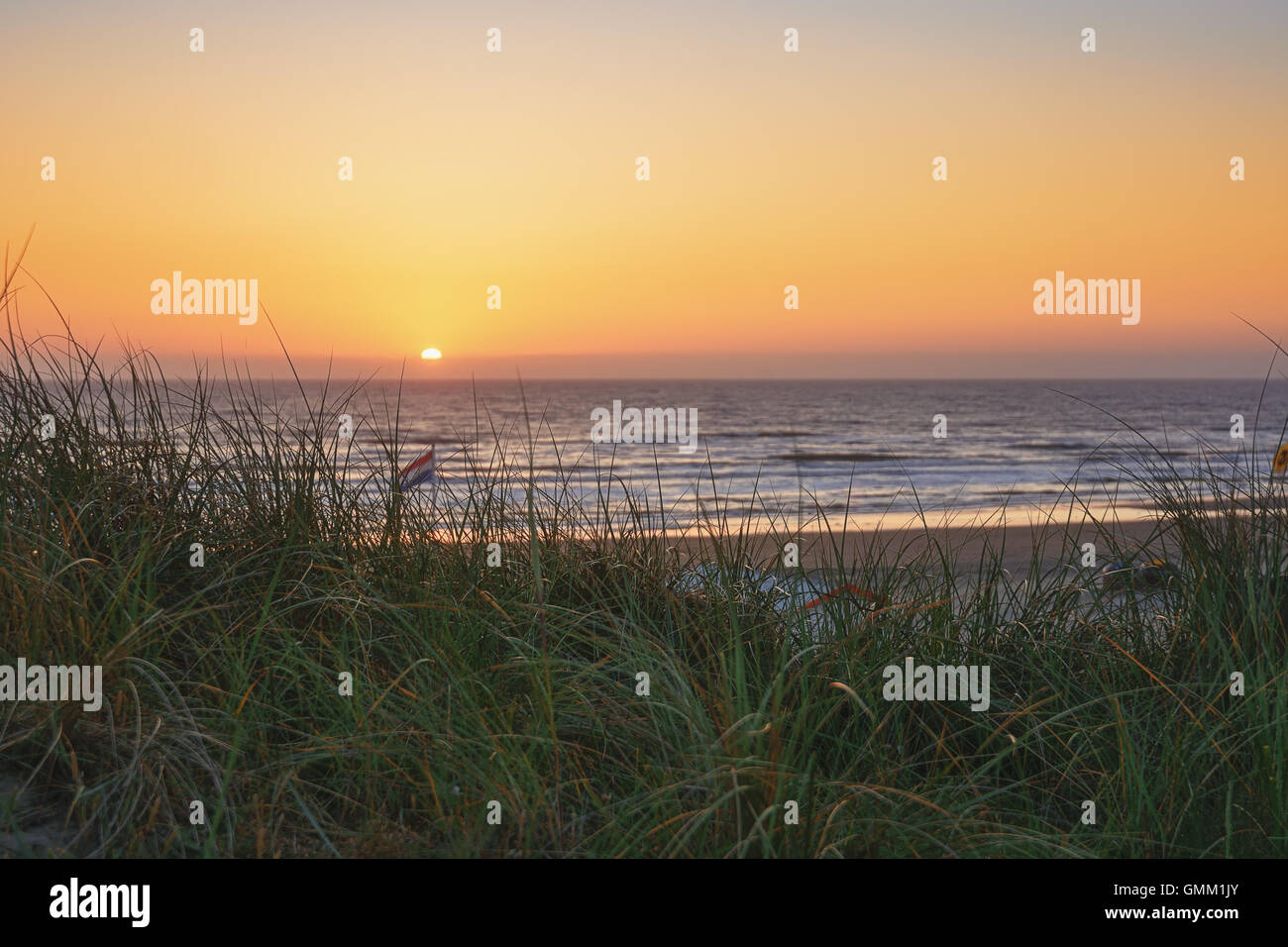 Ein Blick auf die Nordsee durch den Strandhafer während des Sonnenuntergangs. Stockfoto