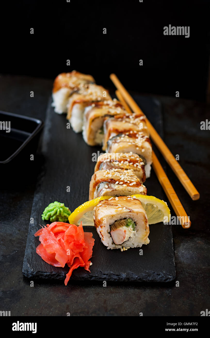 Traditionelles japanisches Essen - Sushi, Brötchen und Sauce auf einem schwarzen Hintergrund. Stockfoto