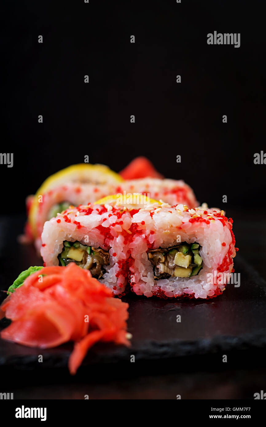 Traditionelles japanisches Essen - Sushi, Brötchen und Sauce auf einem schwarzen Hintergrund. Stockfoto