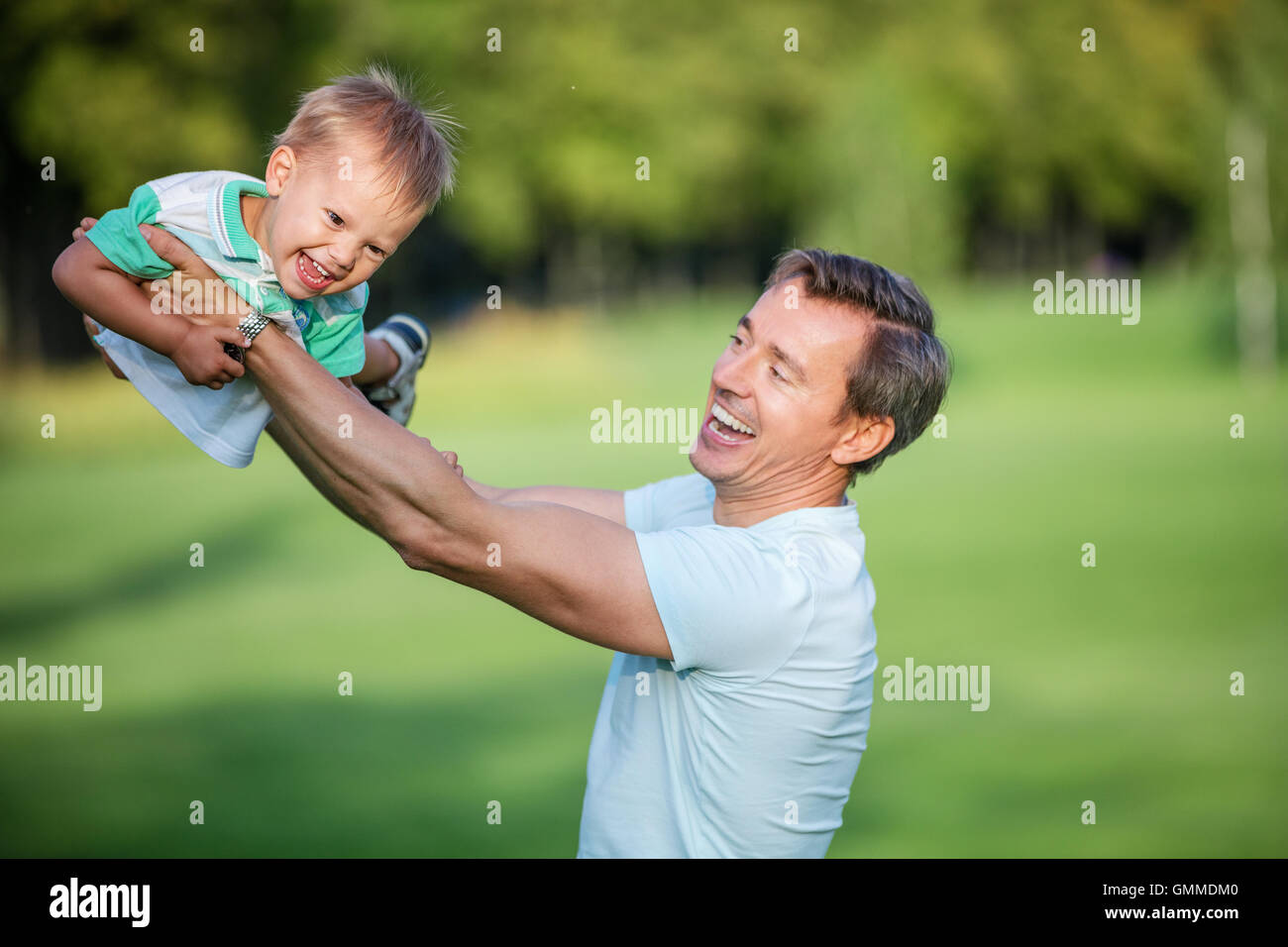 Vater und Kind Sohn Spaß im Sommerpark, fliegen, Spaß, Rasen, Stockfoto