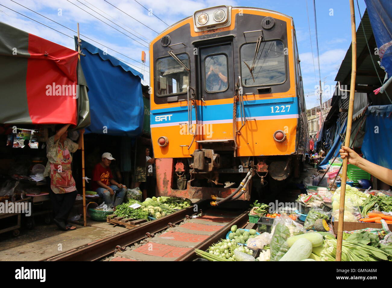 Zug durch Maeklong Zug Markt, einem einzigartigen Markt wo Gemüse Verkäufer ihre waren neben der Bahnstrecke verkehren. Stockfoto