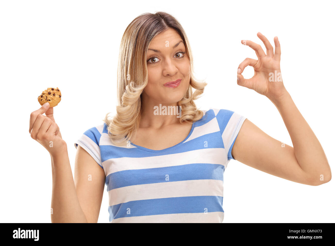 Stets gut gelaunte Frau Essen einen Cookie und ein ok Zeichen isoliert auf weißem Hintergrund Stockfoto